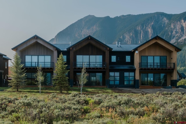 rear view of house with a mountain view and a balcony