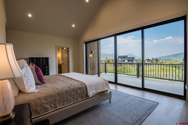 bedroom featuring light hardwood / wood-style flooring, access to outside, and high vaulted ceiling