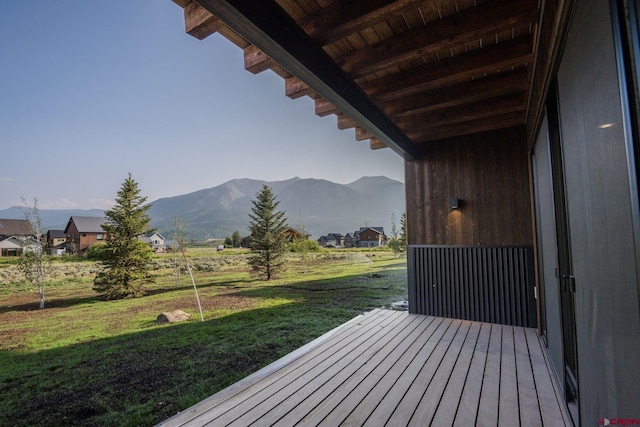 deck with a mountain view and a lawn