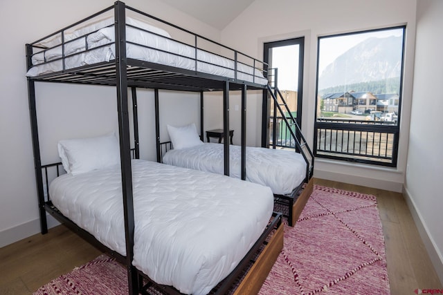 bedroom featuring wood-type flooring and vaulted ceiling