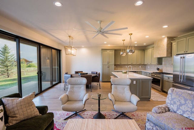 living room with light hardwood / wood-style floors, sink, and ceiling fan