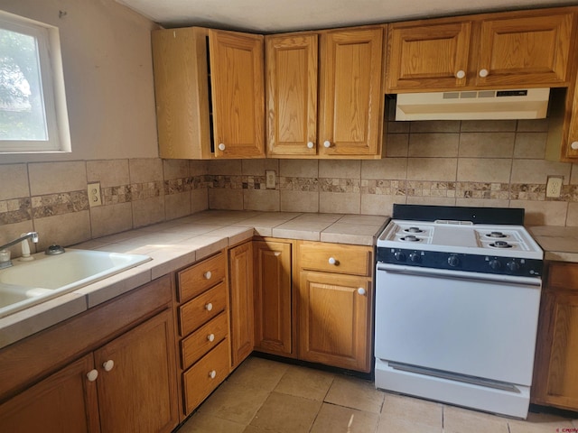 kitchen featuring backsplash, electric stove, wall chimney exhaust hood, and light tile patterned floors