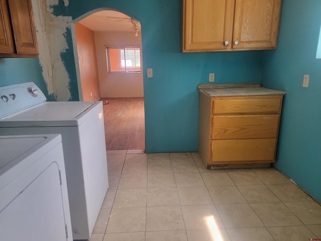 laundry area with cabinets, light tile patterned floors, and independent washer and dryer