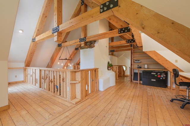 bonus room featuring lofted ceiling with beams and light wood-type flooring