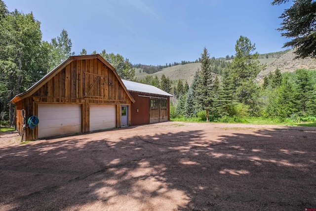 view of home's exterior featuring a garage, an outbuilding, and a mountain view