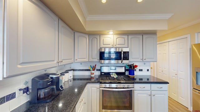 kitchen with stainless steel appliances, tasteful backsplash, dark stone countertops, and crown molding