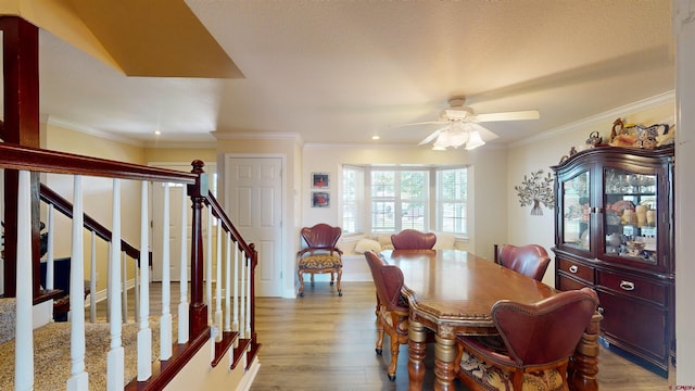 dining room featuring crown molding, stairs, ceiling fan, and wood finished floors