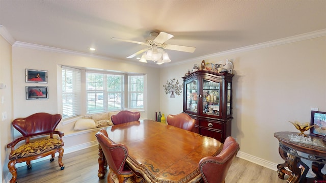 dining space featuring light wood-style floors, baseboards, ornamental molding, and a ceiling fan