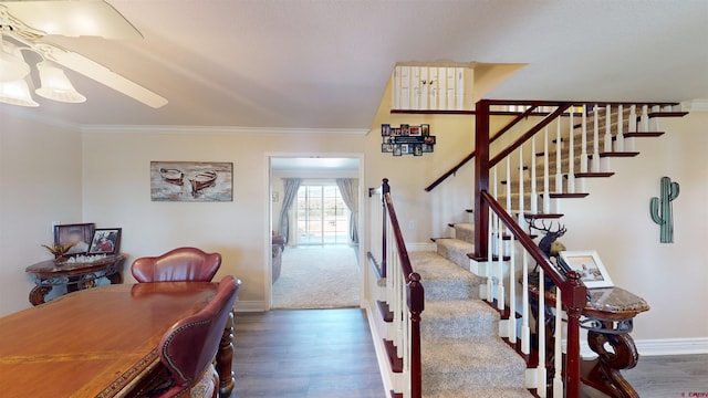 stairs featuring ornamental molding, a ceiling fan, baseboards, and wood finished floors