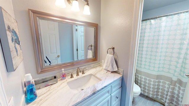 bathroom with toilet, curtained shower, and vanity