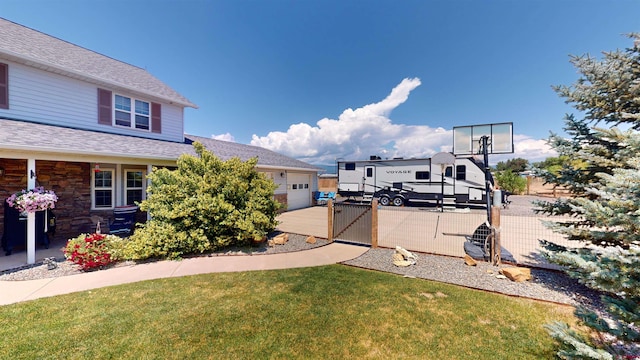 view of yard with concrete driveway, fence, and an attached garage