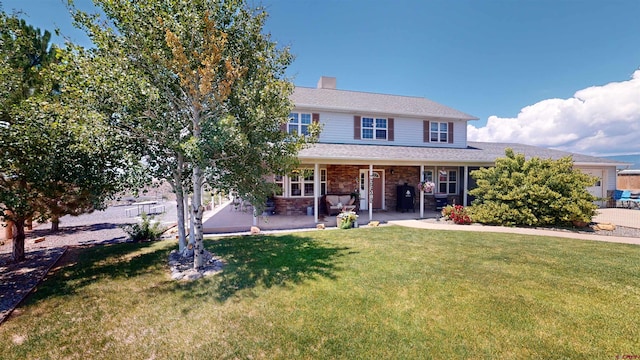 view of front of property with a chimney, a front lawn, and brick siding