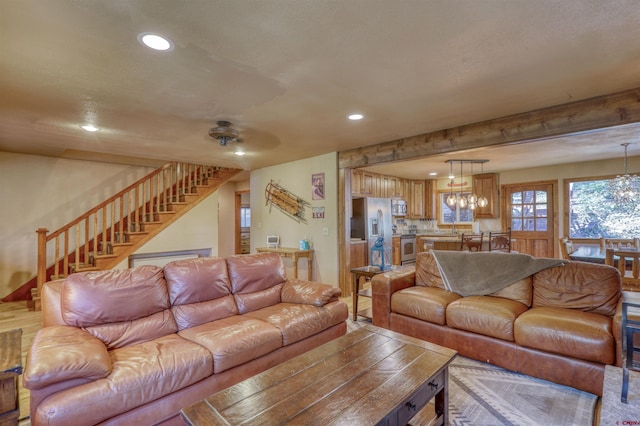 living room featuring recessed lighting, a notable chandelier, and stairway