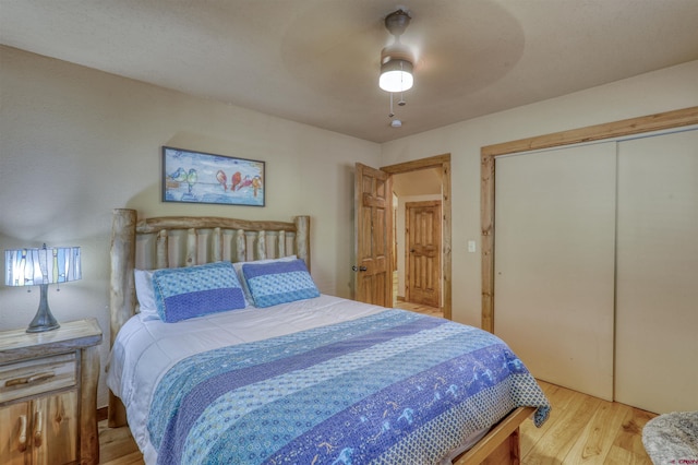 bedroom featuring light wood-type flooring, ceiling fan, and a closet