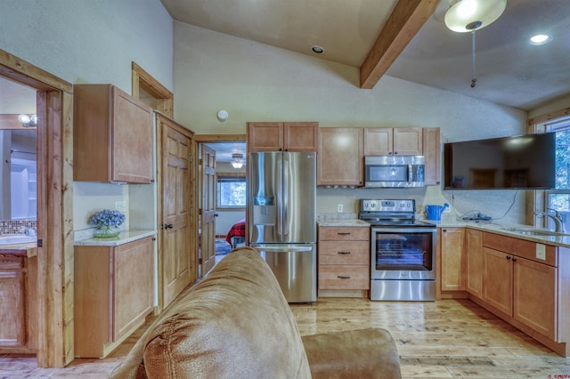 kitchen featuring light wood-style flooring, a sink, appliances with stainless steel finishes, light brown cabinetry, and beamed ceiling