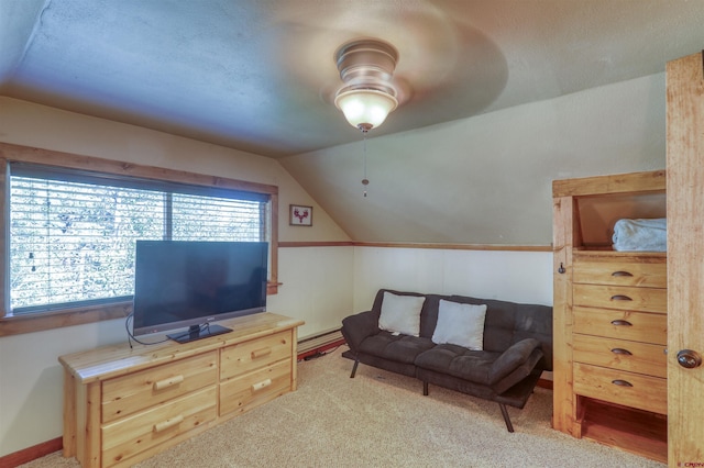 living room with vaulted ceiling, a baseboard heating unit, and light carpet