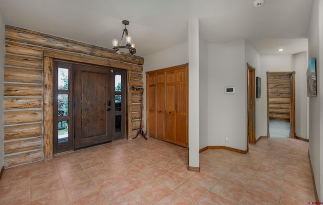 foyer entrance featuring rustic walls and an inviting chandelier