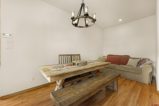 dining area with an inviting chandelier and light hardwood / wood-style floors