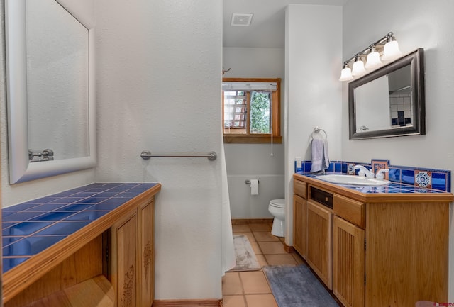 bathroom with vanity, tile patterned floors, and toilet