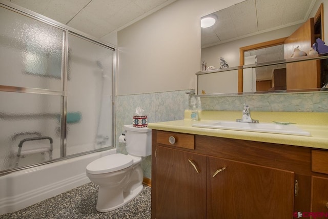 full bathroom with vanity, combined bath / shower with glass door, tile walls, and toilet