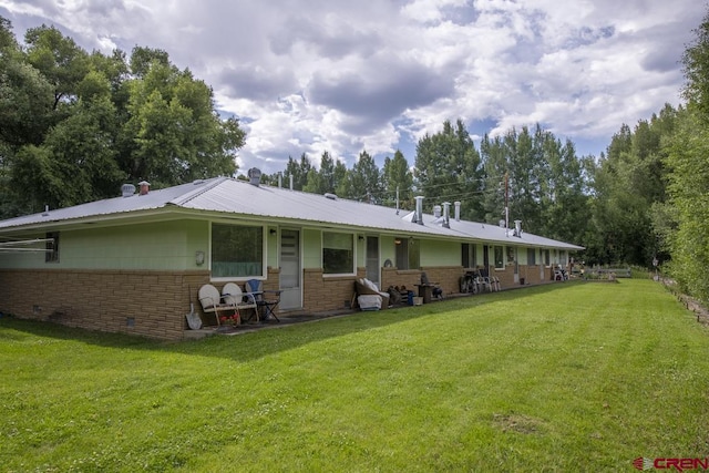 rear view of property featuring a yard