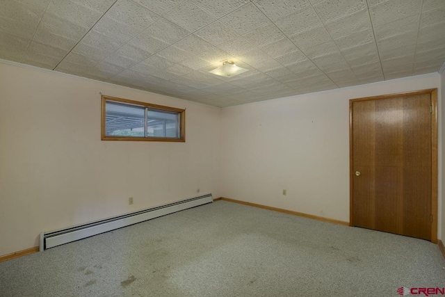 carpeted spare room featuring a baseboard heating unit