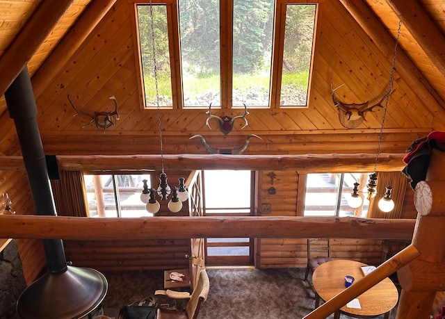 interior space with rustic walls, wood ceiling, and an inviting chandelier