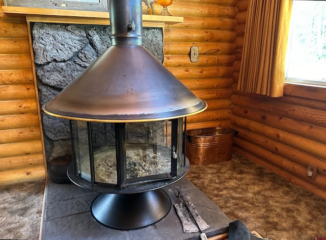 interior details with a wood stove, carpet floors, and rustic walls