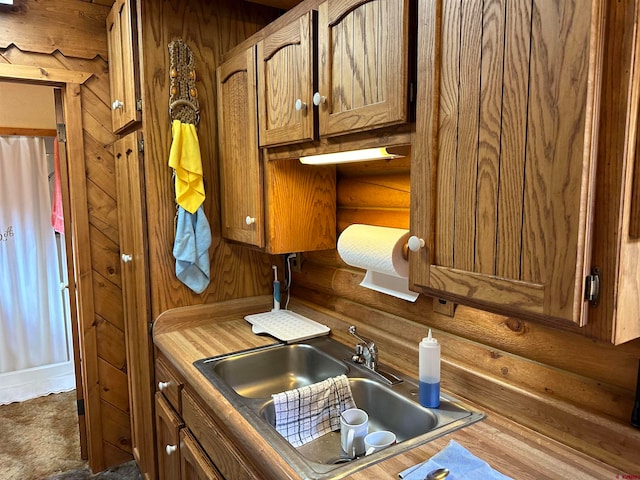 kitchen with sink, hardwood / wood-style flooring, and log walls