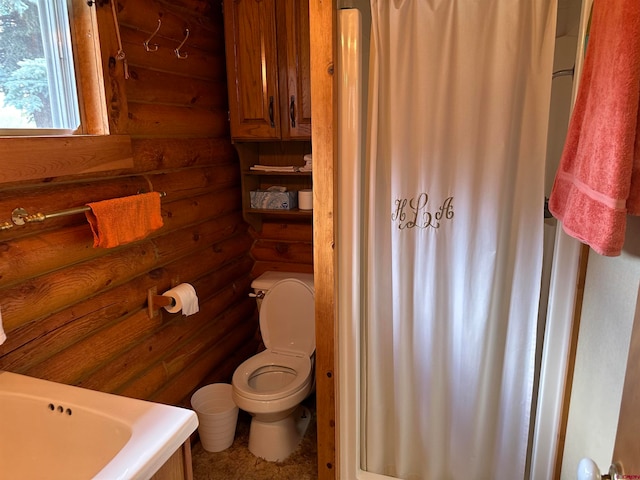 bathroom featuring toilet and log walls