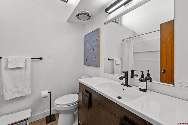 bathroom with vanity, toilet, and curtained shower