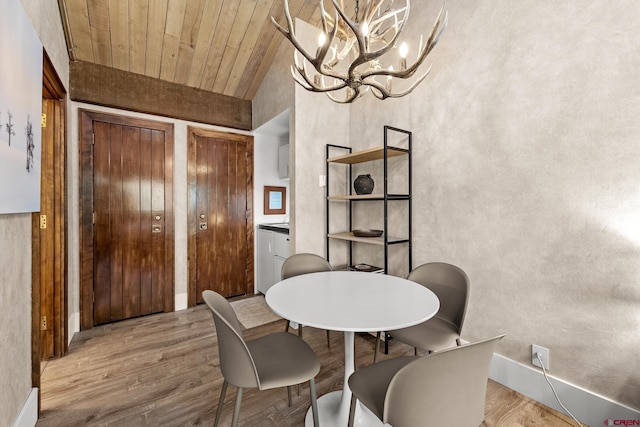 dining area with wood ceiling, lofted ceiling, an inviting chandelier, and light wood-type flooring