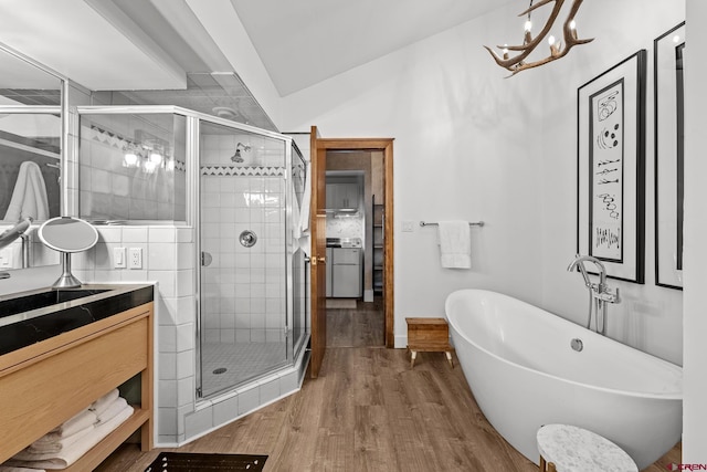 bathroom with plus walk in shower, vaulted ceiling, hardwood / wood-style floors, and a chandelier