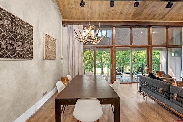 dining area featuring a chandelier, hardwood / wood-style floors, and wooden ceiling