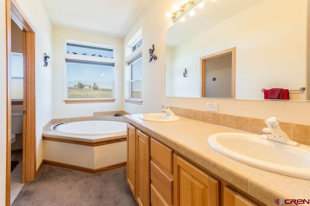 bathroom with vanity, a bath, and toilet