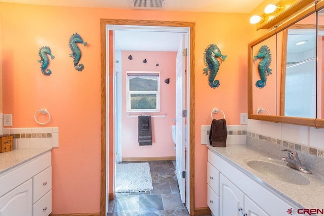 bathroom featuring vanity and decorative backsplash