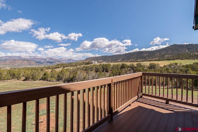 wooden deck featuring a yard and a mountain view