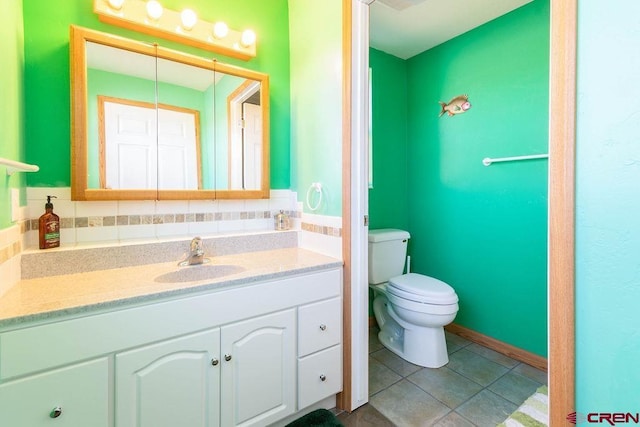 bathroom featuring vanity, toilet, and tile patterned flooring