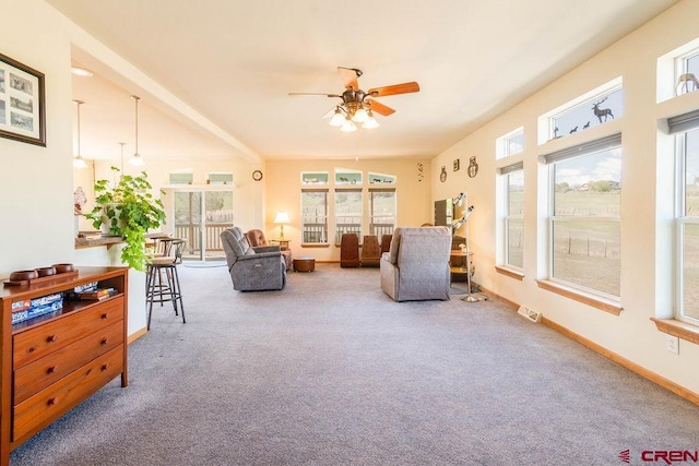 living area with plenty of natural light, ceiling fan, and carpet