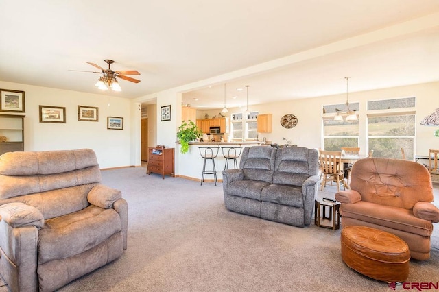 carpeted living room with ceiling fan