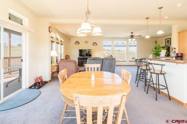 dining room with ceiling fan and light carpet