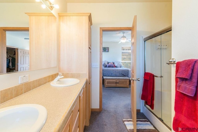 bathroom with a shower with door, vanity, and ceiling fan