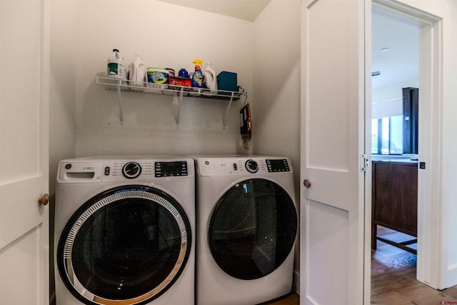 clothes washing area with laundry area, independent washer and dryer, and wood finished floors