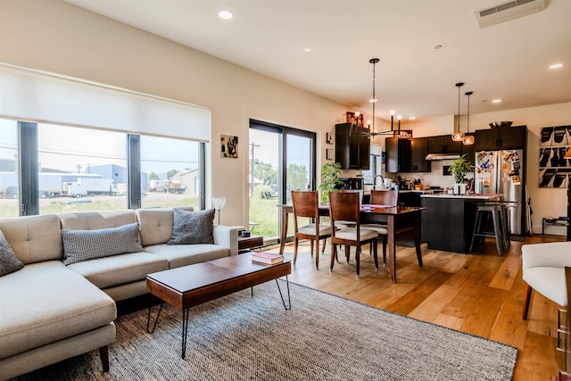 living room featuring a chandelier, recessed lighting, visible vents, and light wood-style floors