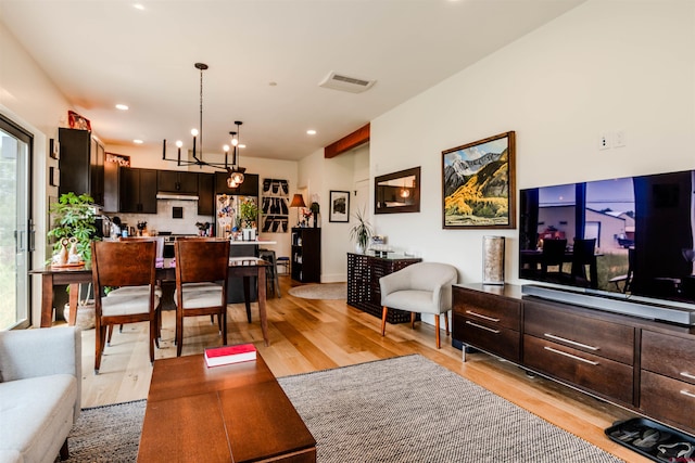 living room with light wood-style flooring, visible vents, a notable chandelier, and recessed lighting