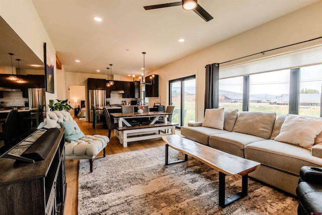 living room featuring hardwood / wood-style flooring and ceiling fan with notable chandelier