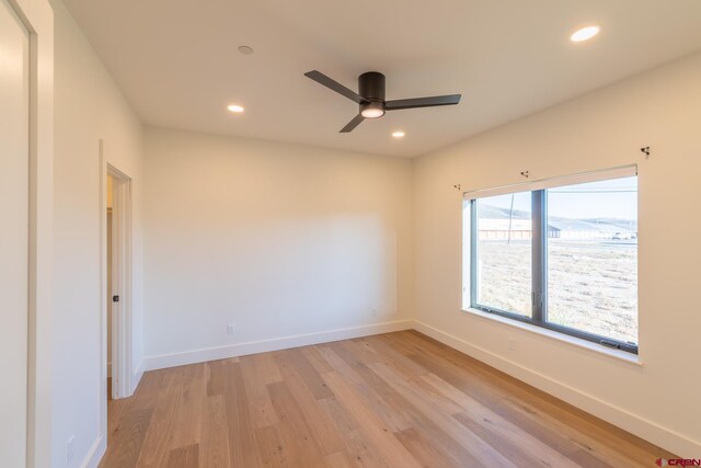 kitchen with light wood-type flooring, a center island, hanging light fixtures, appliances with stainless steel finishes, and decorative backsplash