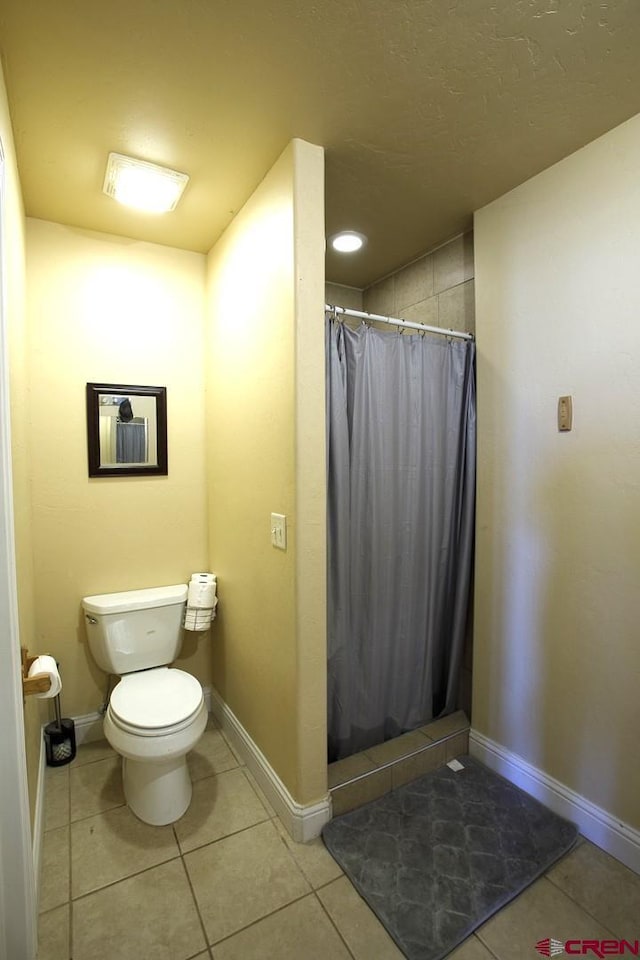 bathroom featuring a shower with curtain, toilet, and tile patterned flooring