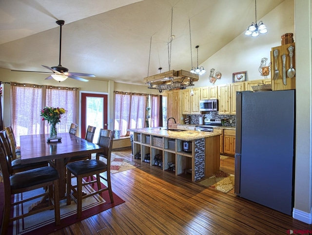 kitchen with a kitchen island with sink, decorative light fixtures, dark wood-type flooring, and stainless steel appliances