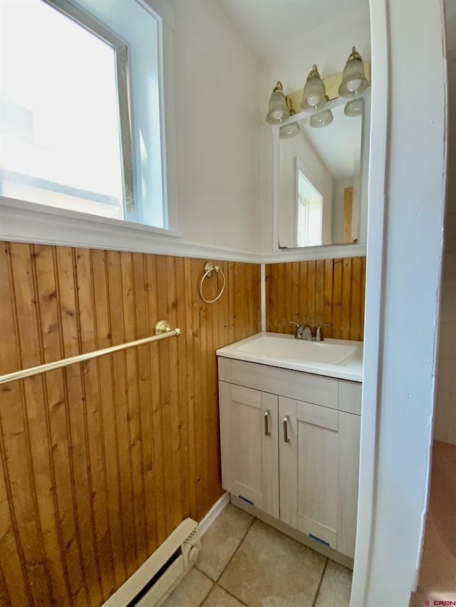 bathroom featuring tile patterned flooring, vanity, wooden walls, and baseboard heating